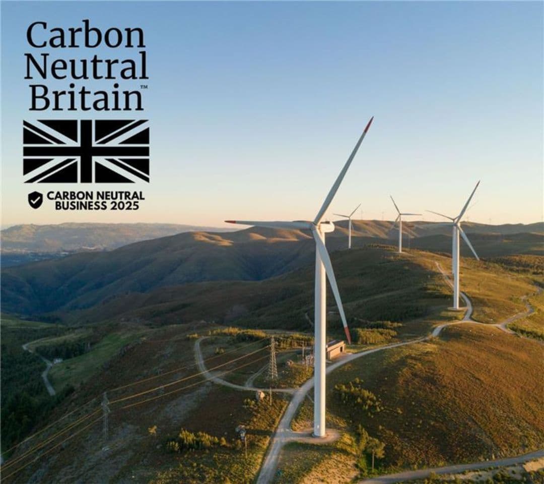 Aerial view of wind turbines on hills, with "Carbon Neutral Britain" logo in the top left corner, promoting sustainability and carbon neutrality.
